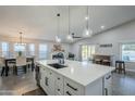 Open kitchen featuring island with quartz countertops, a bar area with stools, and stainless steel appliances adjacent to the dining room at 5507 E Grandview Rd, Scottsdale, AZ 85254