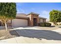 Lovely front exterior with desert landscaping, a two-car garage, and neutral color palette at 676 N 156Th Ln, Goodyear, AZ 85338