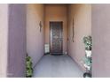 Inviting front entryway featuring a secure iron gate, decorative elements, and shaded porch at 676 N 156Th Ln, Goodyear, AZ 85338