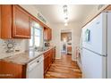 Bright kitchen with stainless steel sink, wood cabinets, modern appliances, and wood flooring at 10407 N 108Th Ave, Sun City, AZ 85351