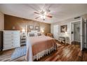 Charming main bedroom with wood floors, a ceiling fan, and a white four poster bed frame at 10407 N 108Th Ave, Sun City, AZ 85351