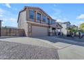 Two-story house with a three-car garage and desert landscaping at 1179 E Coyote Creek Way, San Tan Valley, AZ 85143