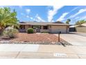 Inviting single-story home with brick accents, well-maintained desert landscaping, and a cozy, gated front porch at 16302 N 36Th Ave, Phoenix, AZ 85053