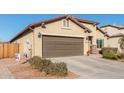 Beautiful home with a well-manicured yard, desert landscaping, and a two-car garage on a bright, sunny day at 17532 W Bajada Rd, Surprise, AZ 85387