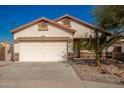 Single-story house with a two-car garage and desert landscaping at 201 2Nd E Ave, Buckeye, AZ 85326