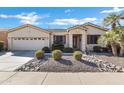 Beautiful desert landscaping around this single-story home with a two-car garage at 20208 N Oxbow Ln, Maricopa, AZ 85138