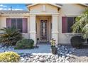 Inviting front entrance with a decorative door and well-maintained landscaping at 20208 N Oxbow Ln, Maricopa, AZ 85138