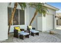 Cozy outdoor patio with wicker furniture and potted palm trees near a three car garage at 2105 N Kachina --, Mesa, AZ 85203