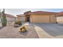 Front view of a tan house with a red tile roof and cacti at 2409 E Antigua Dr, Casa Grande, AZ 85194