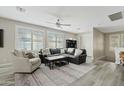 Spacious living room features a comfortable leather sofa, ceiling fan, and a large window at 3021 E Agritopia N Loop, Gilbert, AZ 85296