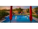 Stunning pool with red umbrellas and inviting patio furniture at 30416 N 64Th St, Cave Creek, AZ 85331