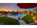 Relaxing pool area with red umbrellas and lush green landscaping at 30416 N 64Th St, Cave Creek, AZ 85331