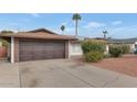 Brown double-door garage with a paved driveway at 3536 W Acapulco Ln, Phoenix, AZ 85053