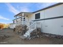 Home exterior showcasing a wooden porch and stonework at 49201 N 24Th Ave, New River, AZ 85087