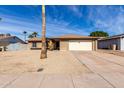 Attractive brick home featuring a two-car garage, desert landscaping, and a quaint front porch at 5114 W Corrine Dr, Glendale, AZ 85304