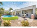 Landscaped backyard oasis with a kidney-shaped pool and patio at 5613 N Laguna Ct, Litchfield Park, AZ 85340