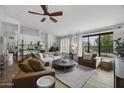 Bright living room boasts neutral décor, a large picture window with shutters, and comfortable seating arrangements on a light-colored rug at 9837 E Pershing Ave, Scottsdale, AZ 85260