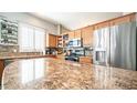 Kitchen boasts granite countertops and wood cabinets at 1022 E Hiddenview Dr, Phoenix, AZ 85048