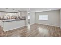 Bright and airy living space with wood-look flooring, seamlessly connecting the kitchen and dining areas at 104 N 114Th St, Apache Junction, AZ 85120