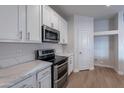 White kitchen with stainless steel appliances and quartz countertops at 10582 W Salter Dr, Peoria, AZ 85382