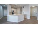 Open concept kitchen with island and white cabinets at 10582 W Salter Dr, Peoria, AZ 85382