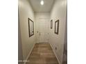 Inviting entryway featuring light wood floors and framed mirrors on the walls at 14575 W Mountain View Blvd # 11210, Surprise, AZ 85374