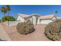 Single-story home with a three-car garage, desert landscaping, and an arched entryway at 1582 W Chicago St, Chandler, AZ 85224
