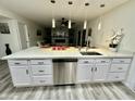 Spacious kitchen with a stainless steel dishwasher, modern pendant lights, and ample counter space at 1708 W Harmont Dr, Phoenix, AZ 85021