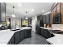 Stylish kitchen boasting dark cabinets, a large island with white countertops, and stainless steel appliances at 21932 E Rosa Rd, Queen Creek, AZ 85142