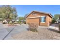 Tan house with a two-car garage and desert landscaping at 2608 E Desert Wind Dr, Casa Grande, AZ 85194
