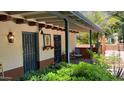 Close up of covered porch with wrought iron doors, sitting area and colorful wall art at 3142 N 27Th St, Phoenix, AZ 85016