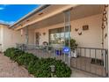 Cozy front porch featuring wrought iron railing, seating area, and manicured landscaping at 5433 E Dodge St, Mesa, AZ 85205