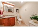 Small bathroom with granite vanity and wood cabinets at 10330 W Thunderbird Blvd # A321, Sun City, AZ 85351