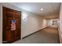 Apartment building hallway with carpet and a wood door at 10330 W Thunderbird Blvd # A321, Sun City, AZ 85351