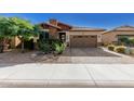 Single-story home with stone and red accents, brown garage door, and landscaped front yard at 12791 W Caraveo Pl, Peoria, AZ 85383