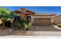 Single-story home with stone and red accents, brown garage door, and landscaped front yard at 12791 W Caraveo Pl, Peoria, AZ 85383