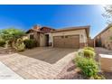 Single-story home with stone and red accents, brown garage door, and landscaped front yard at 12791 W Caraveo Pl, Peoria, AZ 85383