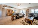 Spacious living room with tile floors, leather furniture, and built-in shelving at 15973 W Sheila Ln, Goodyear, AZ 85395