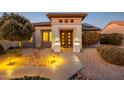 Welcoming front entrance with decorative iron gate and landscape lighting at 16442 W Quarry Ct, Surprise, AZ 85374