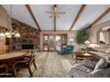 Living room featuring a stone fireplace, hardwood beams, and ample seating at 22206 N La Senda Dr, Scottsdale, AZ 85255