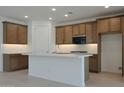 Modern kitchen with stainless steel appliances, a center island, and a stylish backsplash at 24248 W Agora Ln, Buckeye, AZ 85326