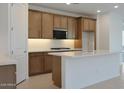 Modern kitchen featuring a spacious island with sleek countertops and custom cabinetry at 24248 W Agora Ln, Buckeye, AZ 85326