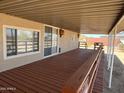 Large, covered back patio with a wooden deck and beige stucco exterior at 29967 N Sandridge Dr, Queen Creek, AZ 85144