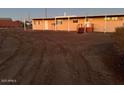 Exterior view of a single story home with a neutral colored exterior, metal storage container and a dirt driveway at 29967 N Sandridge Dr, Queen Creek, AZ 85144