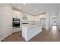 Modern kitchen with white cabinets, stainless steel appliances, and a large island at 34690 N Ashwood Dr, San Tan Valley, AZ 85144