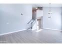 Bright and airy living room featuring vinyl floors and a staircase with a black handrail at 3591 S Larkspur Way, Chandler, AZ 85248