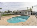 A backyard oasis featuring a refreshing pool, covered patio, grassy area, and mature trees for added privacy at 7018 E Wilshire Dr, Scottsdale, AZ 85257