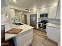 Updated kitchen, featuring white cabinets and quartz countertops at 850 S River Dr # 1002, Tempe, AZ 85281