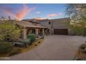 Desert home featuring a tile roof, desert landscaping, and a spacious driveway leading to a large garage at 9290 E Thompson Peak Pkwy # 444, Scottsdale, AZ 85255