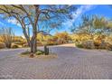 Brick paved driveway leading to a beautiful home with desert landscaping at 10040 E Happy Valley Rd # 595, Scottsdale, AZ 85255